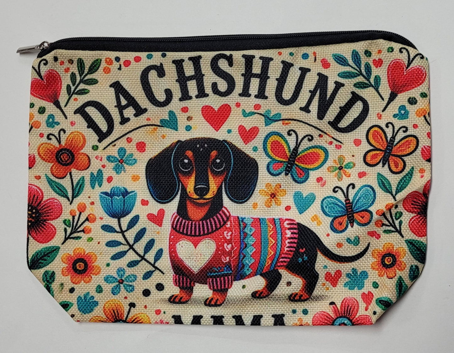 Pouch with a dachshund design and colorful floral patterns on a white background