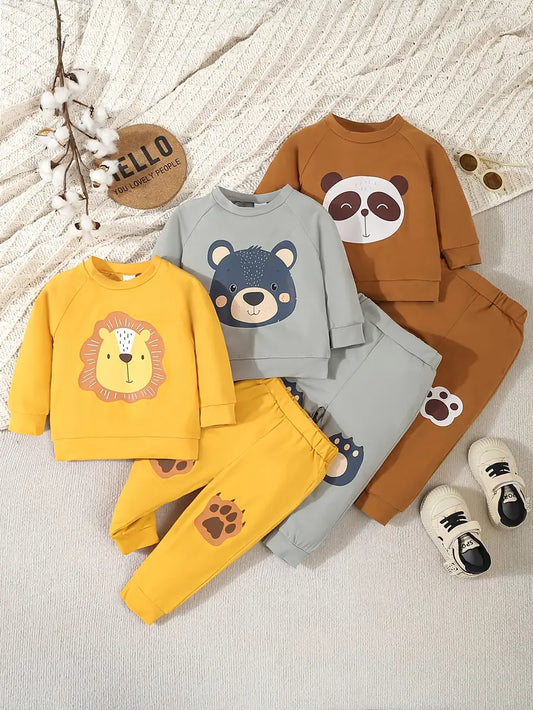 Three children's outfits with animal-themed designs on a textured surface.